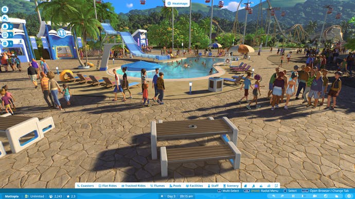 Capture d'écran de Planet Coaster 2 montrant des invités se promenant autour d'une grande place avec une piscine et un toboggan en son centre.